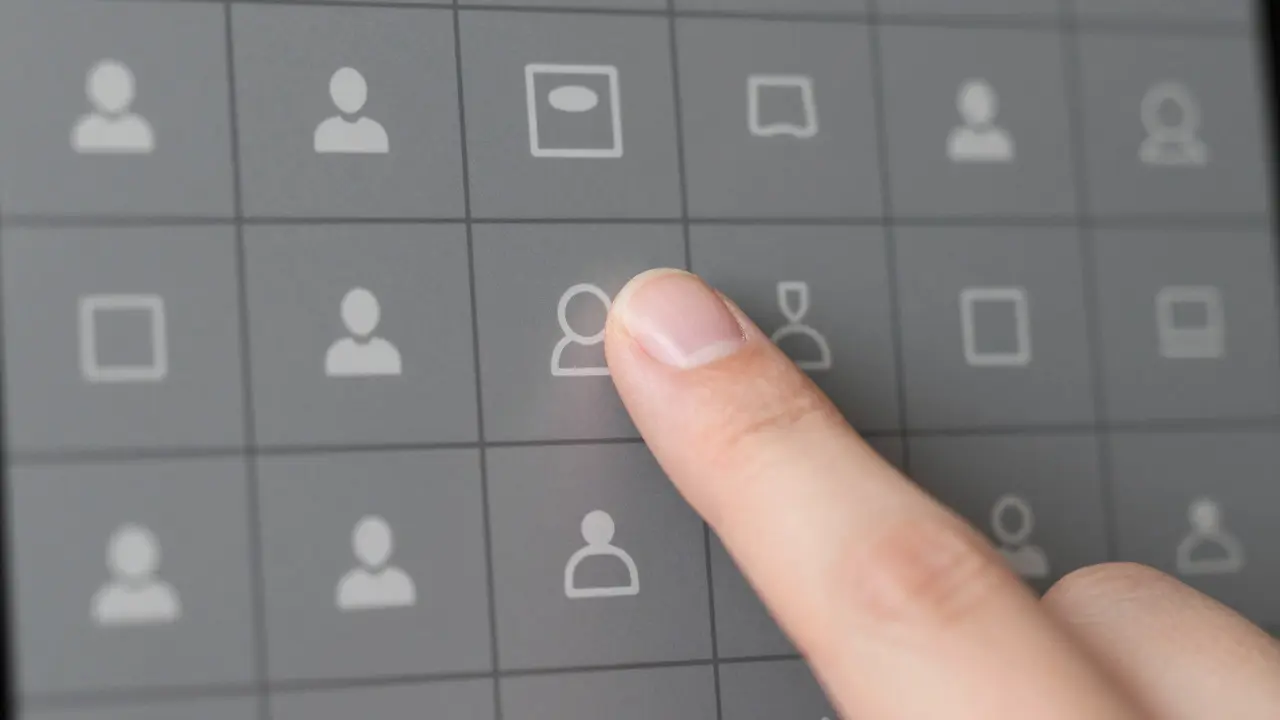 Close-up of finger pressing a grid-aligned button demonstrating consistent UI design